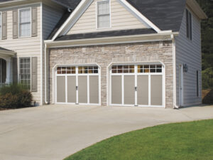 a pair of traditional-style garage doors with gray and white panels